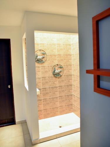 a shower with a glass door in a bathroom at Hotel Iguaraya Inn in Ríohacha