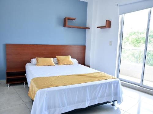 a bedroom with a large bed with a wooden headboard at Hotel Iguaraya Inn in Ríohacha