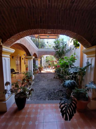 a hallway with an archway with plants in a building at Hotel Nolasco in Antigua Guatemala