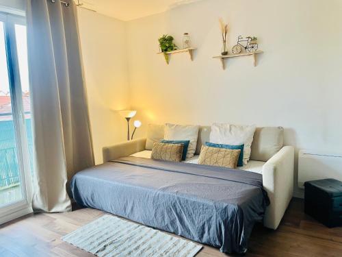 une chambre avec un lit avec des oreillers et une fenêtre dans l'établissement Appartement T2 idéal pour familles ou séjour d affaire, à Argenteuil