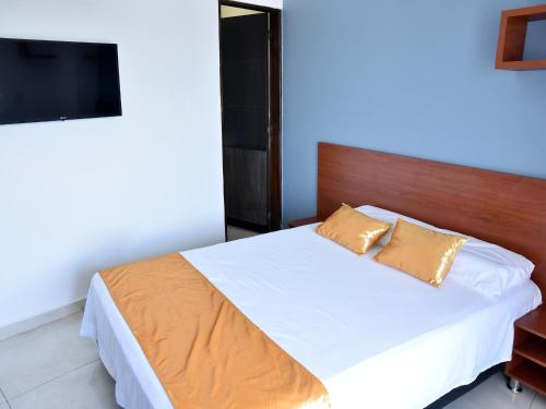a bedroom with a bed and a flat screen tv at Hotel Iguaraya Inn in Ríohacha