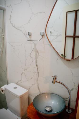 a bathroom with a sink and a mirror and a toilet at Atlantic Pousada in São Sebastião