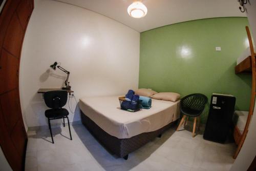 a bedroom with a bed with a green wall at Atlantic Pousada in São Sebastião
