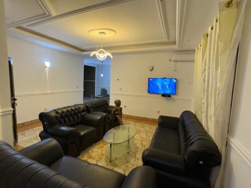 a living room with couches and a flat screen tv at Complexe M Appartement meuble 3 chambres , 2 salles de bains une cuisine in Yaoundé