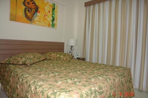 a bedroom with a bed and a painting on the wall at Veredas - Rio Quente Temporada in Rio Quente