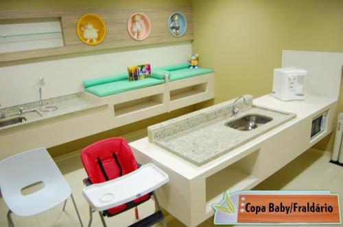 a bathroom with a sink and a red chair at Veredas - Rio Quente Reservas in Rio Quente