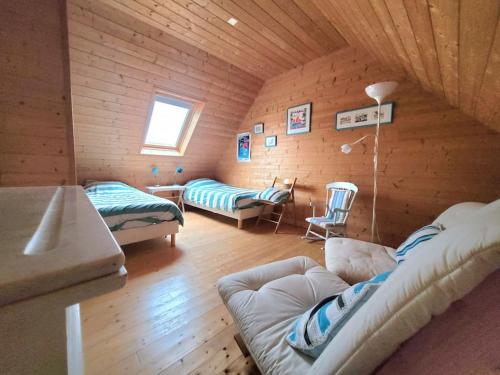 - un salon avec un canapé dans une pièce en bois dans l'établissement Maison plain pied 5 CH, littoral sud pays Bigouden, à Penmarcʼh
