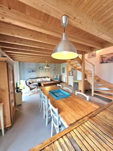 une salle à manger avec une grande table et des chaises en bois dans l'établissement Maison plain pied 5 CH, littoral sud pays Bigouden, à Penmarcʼh