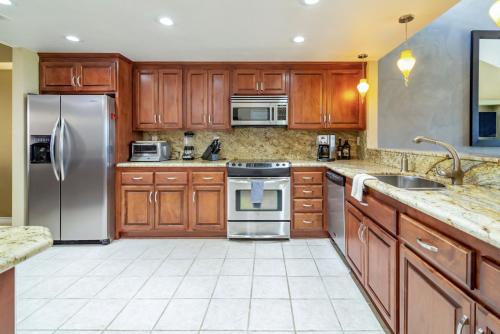 a kitchen with wooden cabinets and stainless steel appliances at The Country Club Experience in Palm Desert