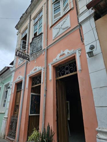 a pink building with a door and windows at Pousada Labarca in Cachoeira