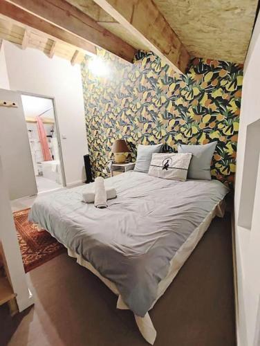 - un grand lit dans une chambre dotée d'un mur avec des feuilles dans l'établissement logement près des volcans, à Durtol