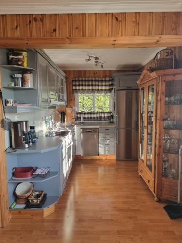a large kitchen with wooden floors and stainless steel appliances at Sunne Stugcenter 12 in Gräsmark