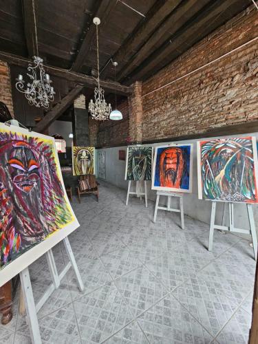 a room full of paintings on display in a brick wall at Pousada Labarca in Cachoeira