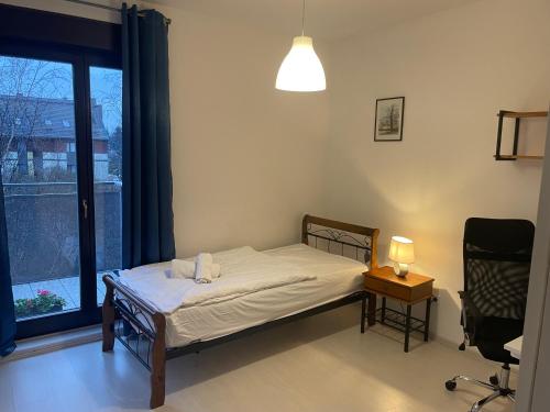 ヴロツワフにあるMotylkowa 125 m2 Apartament 5 pokoiのベッドルーム1室(ベッド1台、窓、椅子付)