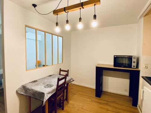 a dining room with a table and a microwave at Bel appartement avec place de parking privative in Aix-les-Bains