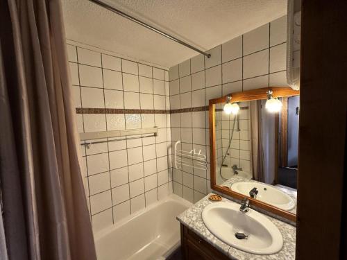 une salle de bain avec un lavabo, une baignoire et un miroir dans l'établissement Résidence Croix Du Sud - 3 Pièces pour 7 Personnes 551, à Aime La Plagne