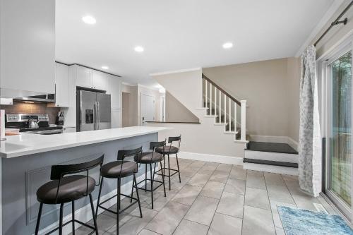 a kitchen with a bar with stools in it at Hillside Packers Haven by Simple Life Rentals in Green Bay