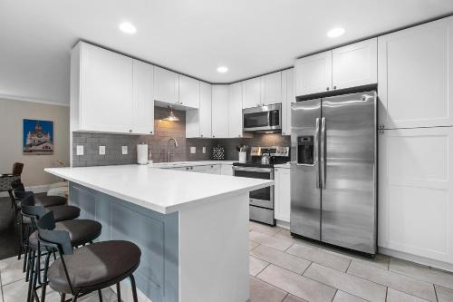 a kitchen with white cabinets and stainless steel appliances at Hillside Packers Haven by Simple Life Rentals in Green Bay