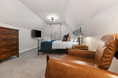 a bedroom with a bed and a couch and a chair at Hillside Packers Haven by Simple Life Rentals in Green Bay
