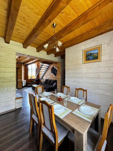 een eetkamer met een houten tafel en stoelen bij Панорама гір in Boekovel