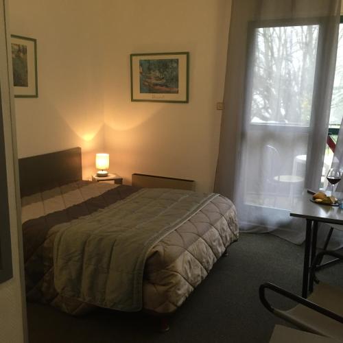 une chambre d'hôtel avec un lit et une fenêtre dans l'établissement Le Pavillon, à Cours-la-Ville