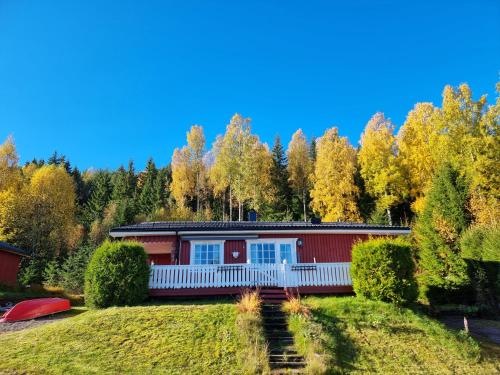 a red house on a hill with trees in the background at Sunne Stugcenter 12 in Gräsmark