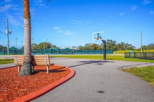 a park with a bench next to a palm tree and a basketball hoop at Sebring Retreat with Direct Golf Course Access! in Sebring