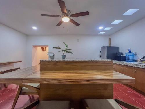 a kitchen with a wooden table and a ceiling fan at 4 Br semi luxury house in downtown with pool - Casa San Juan in Valladolid