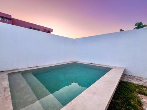 a swimming pool on the side of a white building at 4 Br semi luxury house in downtown with pool - Casa San Juan in Valladolid