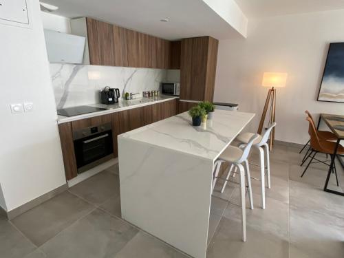 - une cuisine avec un comptoir blanc et des chaises dans l'établissement Fabulous Two-Bedroom Apartment with parking, à Antibes