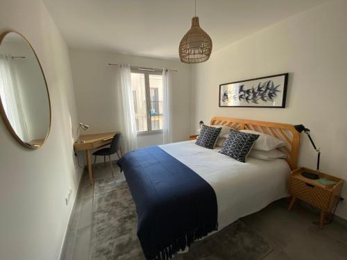 une chambre avec un lit, un miroir et un bureau dans l'établissement Fabulous Two-Bedroom Apartment with parking, à Antibes