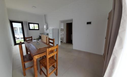 Una cocina y un comedor con mesa y sillas. en complejo OHANA, en Potrero de los Funes