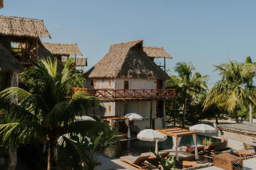 a resort with a swimming pool and palm trees at Aldea Kuká, Luxury Eco Boutique Hotel in Holbox Island
