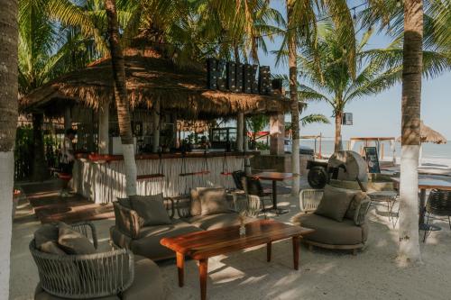a bar with chairs and tables on the beach at Aldea Kuká, Luxury Eco Boutique Hotel in Holbox Island