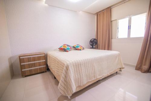 a bedroom with a bed with two pillows on it at Casa c/4 quartos e Piscina - Excelente localização in Caldas Novas