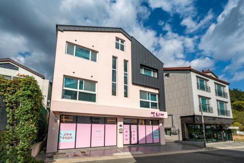 a building with pink garage doors on a street at Yeonhuijae Pool Villa Private Beomeo Branch in Yangsan