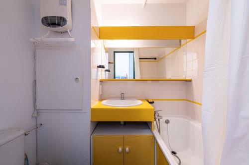 a bathroom with a yellow sink and a mirror at Appartement Les Menuires in Les Menuires