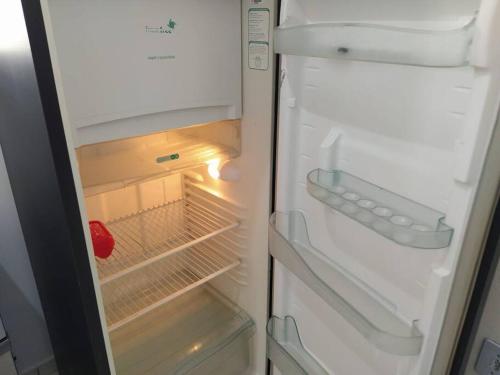 an empty refrigerator with its door open with its door at 101 Apt funcional prox ao centro in Vitória da Conquista
