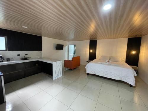 a bedroom with a bed and a desk and a sink at Cabinas La Catarata in Fortuna