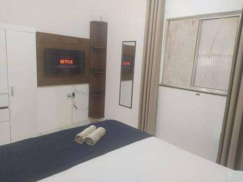 a bedroom with a bed with a clock on the wall at 101 Apt funcional prox ao centro in Vitória da Conquista