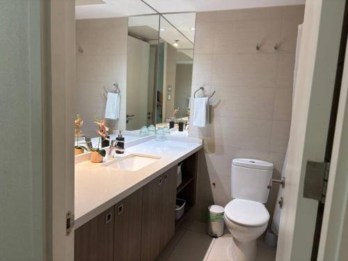 a bathroom with a sink and a toilet and a mirror at Las Condes De Lujo in Santiago