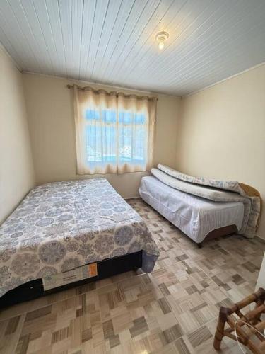 Ένα ή περισσότερα κρεβάτια σε δωμάτιο στο Casa com Piscina em Pontal do Sul