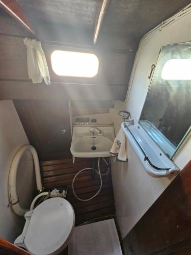 une petite salle de bain avec toilettes et lavabo dans l'établissement Voilier Santana à Cannes, à Cannes