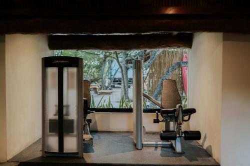 a room with a gym with a chair and a mirror at Aldea Kuká, Luxury Eco Boutique Hotel in Holbox Island