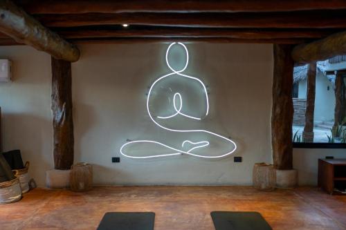 a neon sign on a wall in a room at Aldea Kuká, Luxury Eco Boutique Hotel in Holbox Island
