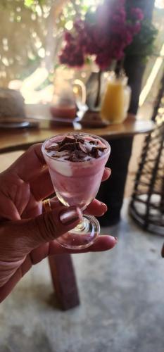 a person holding a drink in a wine glass at Pousada Águas de Tamandaré in Tamandaré