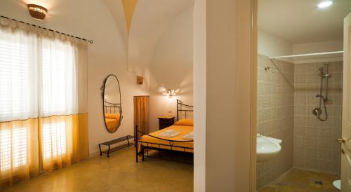 um quarto com uma cama, um chuveiro e um lavatório. em B&B La Garolla em Sannicola