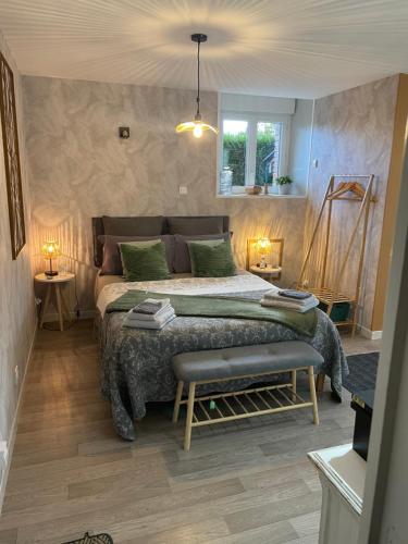 une chambre avec un grand lit dans une pièce dans l'établissement chambre studio Louisette, à Courson