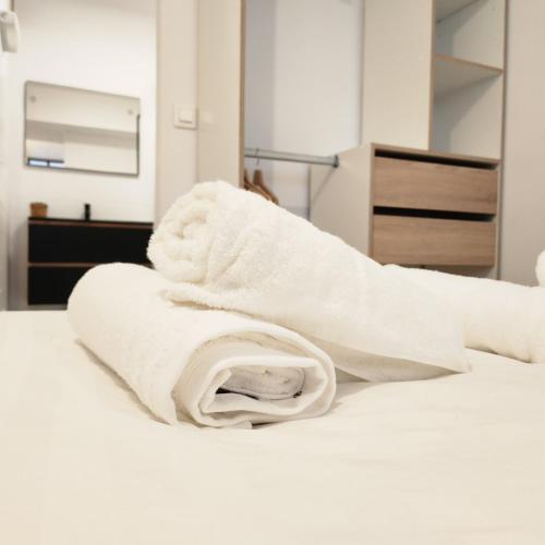 a white towel sitting on top of a bed at Le CoCon palois in Pau