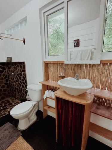 a bathroom with a sink and a toilet at Saasil Retreat in Tzununá